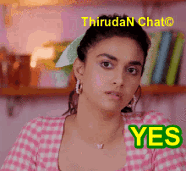 a woman in a pink and white checkered shirt is giving a yes sign .