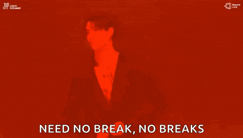 a man with a tattoo on his back is standing in a dark room with the words `` need no break , no breaks '' .