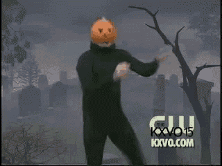 a man with a pumpkin on his head is dancing in a cemetery with the words kxvo 15 on the bottom