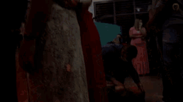 a man wearing a mask is kneeling down in a crowd of people