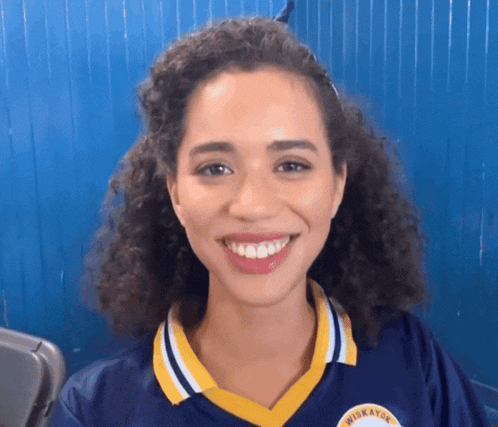 a woman wearing a jersey that says wickayou smiles