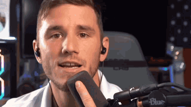 a man wearing earbuds and a blue microphone
