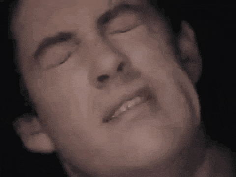 a close up of a man making a face with his eyes closed .