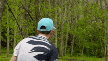 a man wearing a blue hat and a shirt with the word disc golf on the back