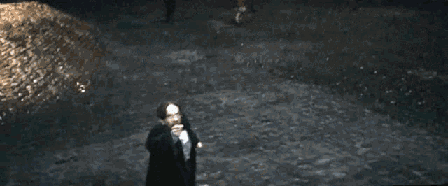 a person is standing in the dark with a light coming out of their head .