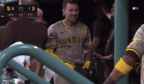 a man in a san diego jersey stands in front of a scoreboard
