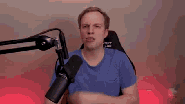 a man is making a funny face in front of a microphone .