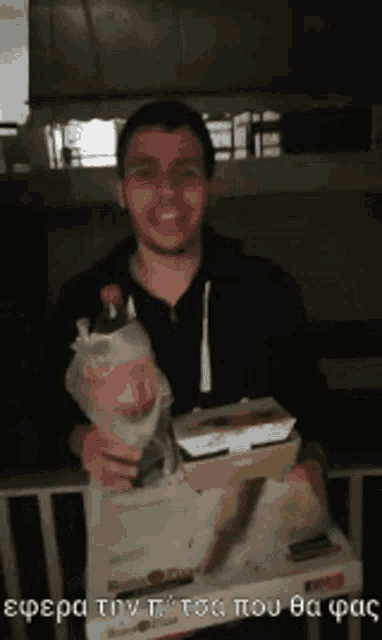 a man holding a bag of food and a box of food with a foreign language written below him