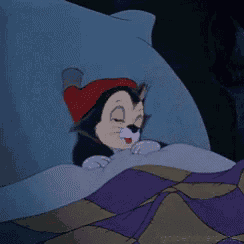 a cartoon cat wearing a red hat is sleeping in bed .