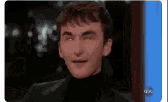 a man is making a funny face while wearing a turtleneck sweater .