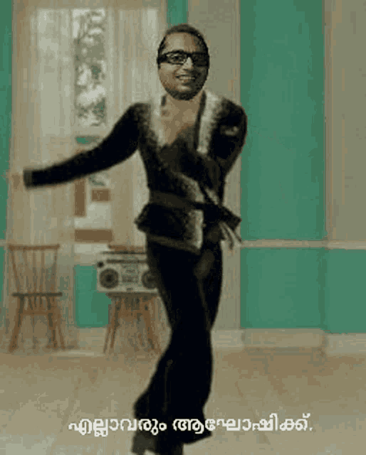 a man in a black suit is dancing in a room with a radio .