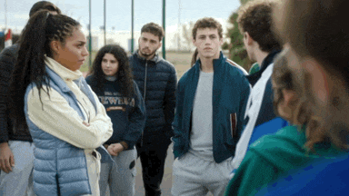 a group of people are standing in a circle and one of them is wearing a jacket that says new york