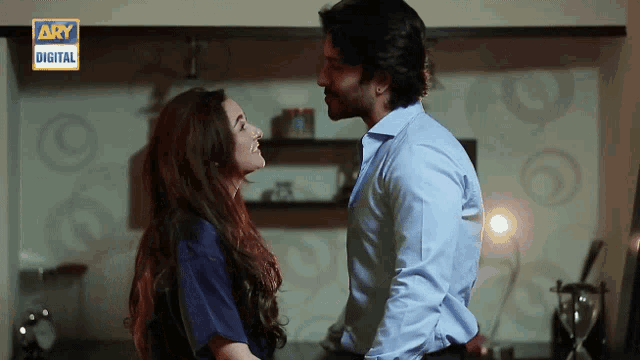 a man and woman are kissing in front of a wall that says ary digital on it