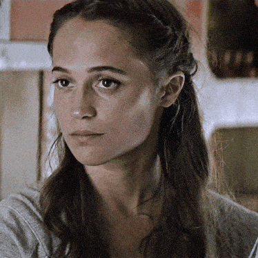 a close up of a woman 's face with a gray shirt on
