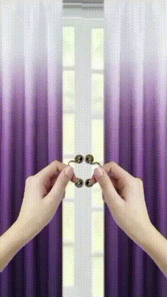 a person is holding a pair of clips in front of a purple curtain .