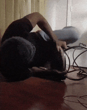 a person is laying on their back on the floor holding a cord