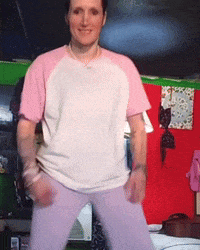 a woman wearing a pink and white shirt and purple pants