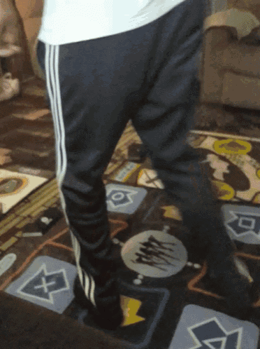 a person is standing on a dance mat with a blue arrow pointing to the left