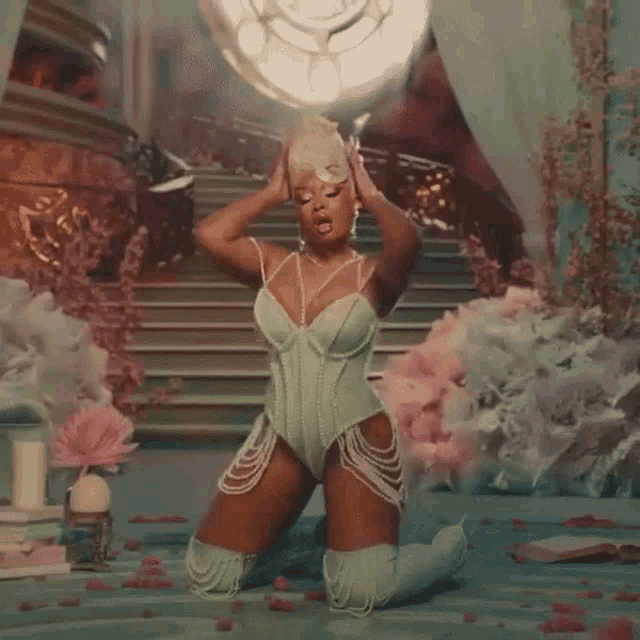 a woman in a green corset is standing in front of a set of stairs