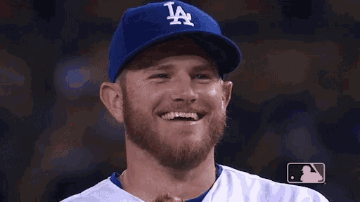 a man with a beard is wearing a la hat and smiling