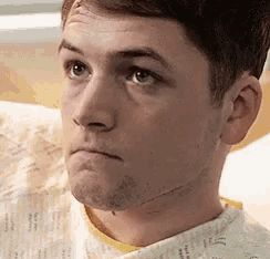 a close up of a man 's face in a hospital gown with a scar on his neck .