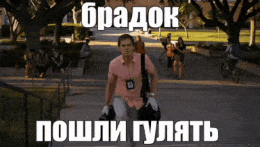 a man in a pink shirt is walking down a sidewalk with a bag on his shoulders and a foreign language caption