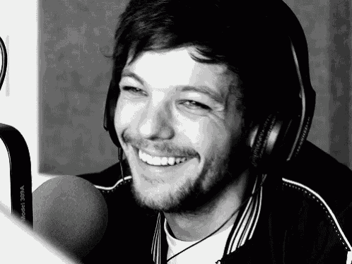 a man wearing headphones is smiling while talking into a microphone