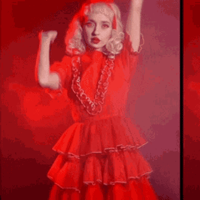 a woman in a red dress with ruffles and a bow on her head