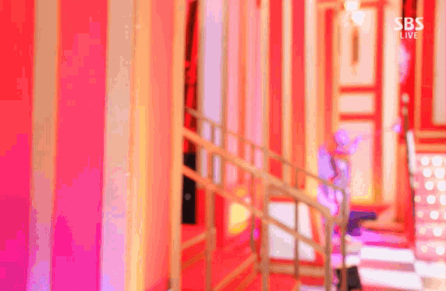 a blurred image of a staircase with the words sbs live on the bottom right