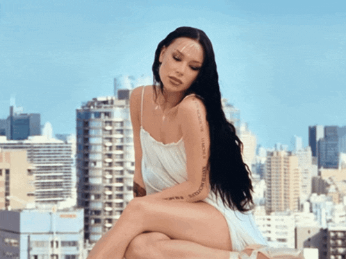 a woman in a white dress has a tattoo on her arm that says ' sydney motors '