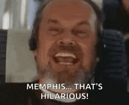 a man with a beard is laughing while wearing headphones .
