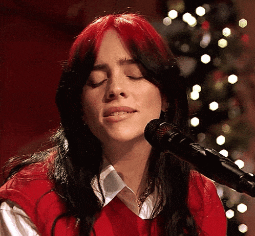 a woman with red hair sings into a microphone
