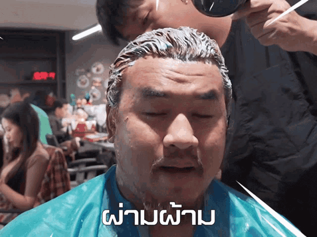 a man is getting his hair dyed in a barber shop with a caption that says ' a ' on it
