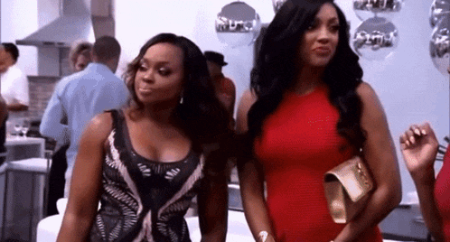 two women are standing next to each other at a party .