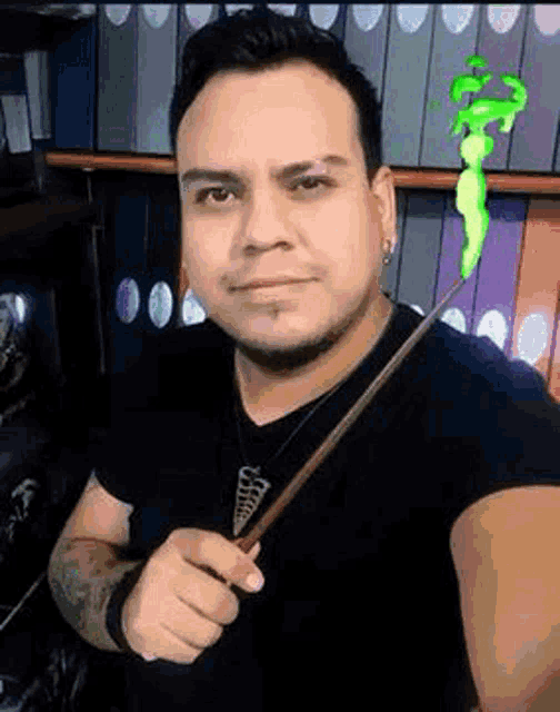 a man is holding a wand in his hand in front of a shelf of binders .