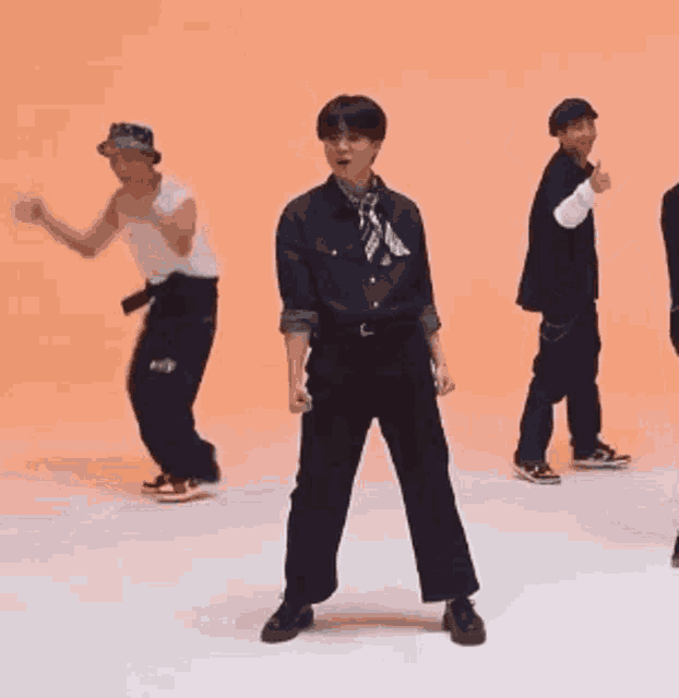 a group of young men are dancing on a white surface .