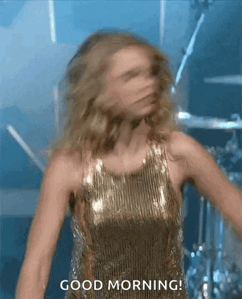 a woman in a gold dress is dancing on stage .