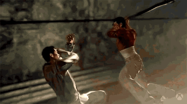 two men are fighting with swords in a boxing ring