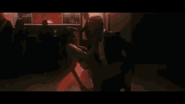 a man in a tuxedo is kissing a woman on the floor