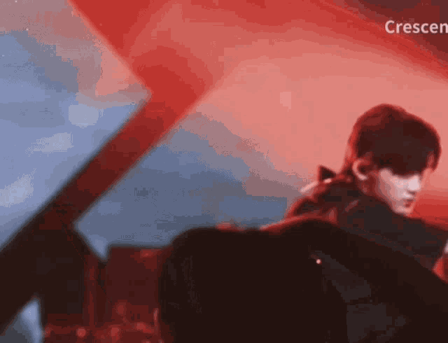a person is standing in front of a red and blue background with the word crescent in the corner