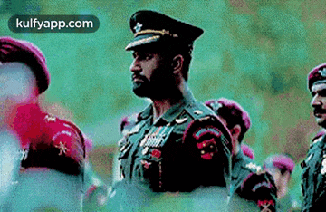 a man in a military uniform is standing in a line with other men in military uniforms .