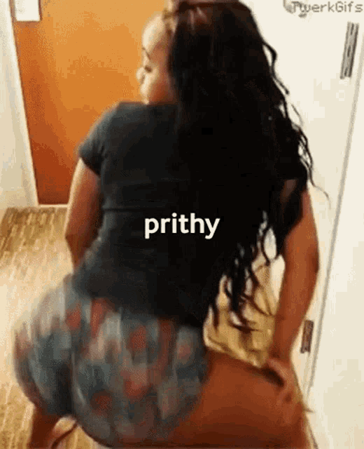 a woman is squatting down on the floor with the word prithy written on her back .