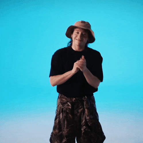 a person wearing a hat and a black shirt is dancing