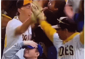 a man wearing a san diego padres jersey holds another man 's hand over his head