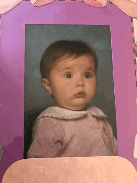 a picture of a baby girl in a pink polka dot shirt