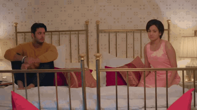 a man and a woman sit on a bed in a bedroom