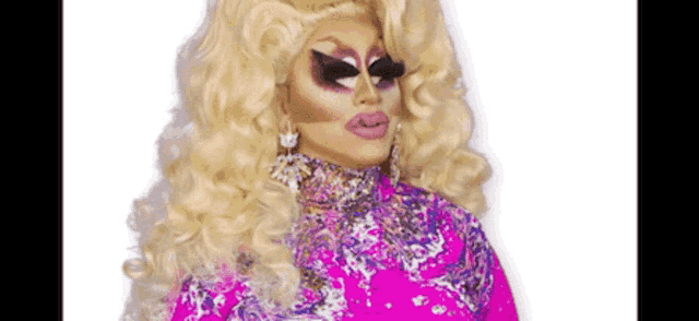 a drag queen is wearing a pink dress and a wig .