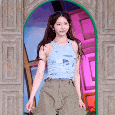 a woman in a blue tank top and khaki pants