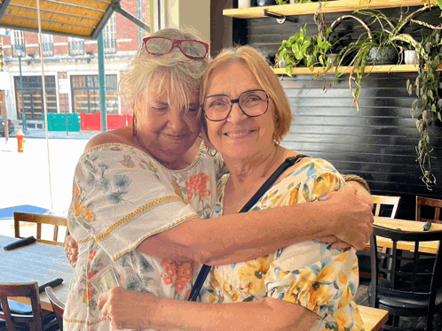 two women hugging each other in a restaurant