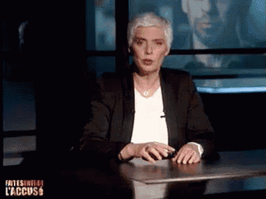 a woman is sitting at a desk in front of a screen that says l' accuss